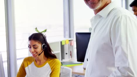 Ejecutivo-con-auriculares-usando-computadoras-en-el-escritorio-en-la-oficina-4k