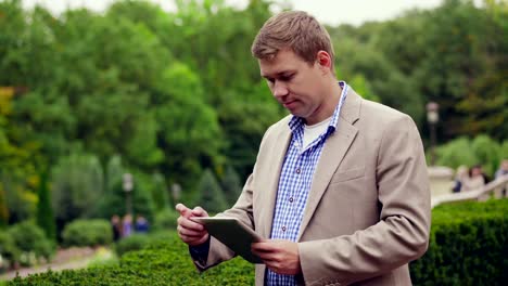 Young-Man-With-Tablet-Computer-In-Park