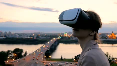 Frau-nutzt-virtual-Reality-Brille-in-der-Stadt-nach-Sonnenuntergang