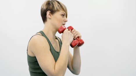 Woman-makes-punches-with-dumbbells-in-the-gym