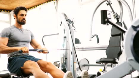 Hombre-guapo-joven-haciendo-ejercicios-en-gimnasio