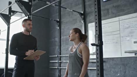 Athletic-Woman-Doing-Chin-Ups-with-Personal-Coach