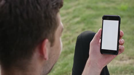 A-Young-Man-Using-a-Phone-Outdoors