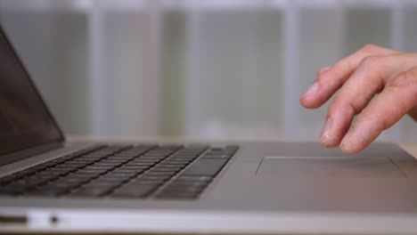 Close-up-touchpad-and-keyboard-of-laptop.-Male-fingers-gestures-at-trackpad.