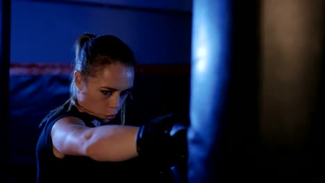 Chica-es-el-boxeo.-Kickboxing-hermosa-mujer-entrenamiento-saco-de-boxeo.-Puño-de-mujer-combatiente-de-cerca.