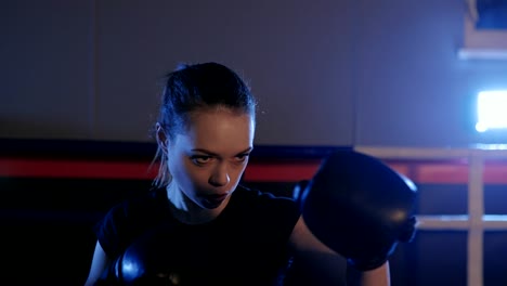 Schöne-Kickboxen-Frau-Boxer-werfen-Schläge-in-die-Boxing-Hall.