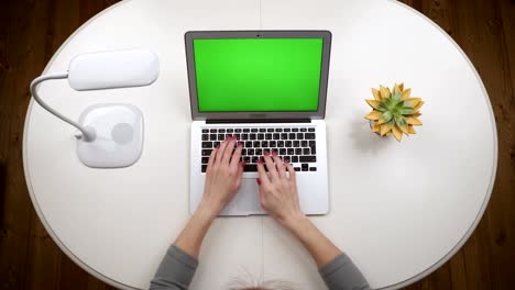 Woman-opens-a-laptop,-standing-on-the-white-table-with-lamp,-typing-text-and-closing-a-laptop.-Top-view.-Hands-close-up