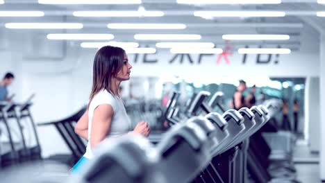 Adult-woman-runs-on-treadmill-at-the-fitness-centre.-Attractive-sporty-girl-running-on-the-treadmil