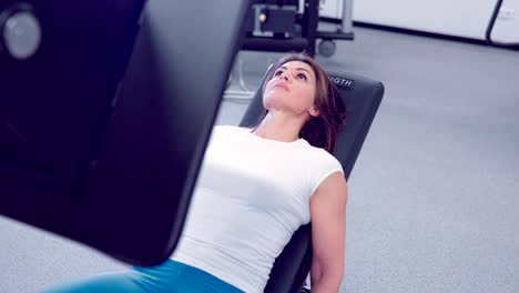 Adult-woman-makes-a-аoot-press-in-the-simulator.-Fitness-girl-workout-with-simulator-leg-press-at-gym