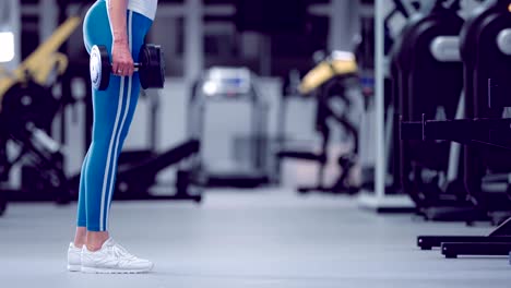 Posición-en-cuclillas-de-mujer-fitness-para-fortalecer-piernas-y-glúteos.-calentamiento-se-pone-en-cuclillas-con-pesas.-Atleta-hace-calentamiento-sentadillas-con-pesas