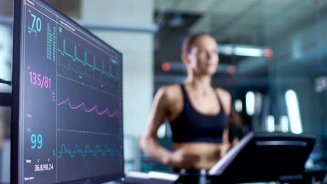 Medical-Monitor-Shows-EKG-Reading-of-a-Woman-Athlete-Running-on-a-Treadmill.-Focus-on-Monitor.