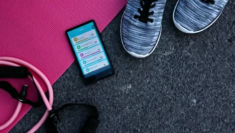 Draufsicht-des-Trainings-Zubehör-und-Smartphone-mit-Fitness-Anwendung