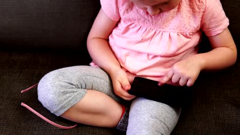 Little-girl-playing-in-the-smartphone