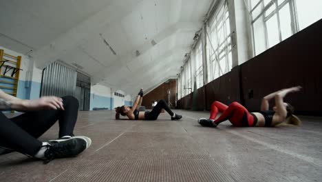 Sportswomen-Doing-Crunches-in-Gymnasium