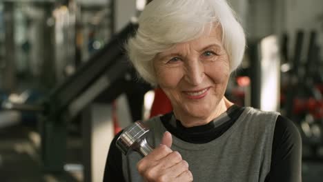 Elderly-Woman-with-Dumbbell-Smiling-for-Camera