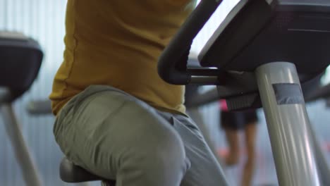 Hombre-de-entrenamiento-en-bicicleta-estacionaria-en-gimnasio