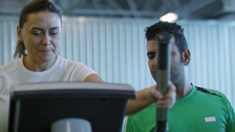 Friends-Racing-Each-Other-on-Elliptical-Machines-in-Gym