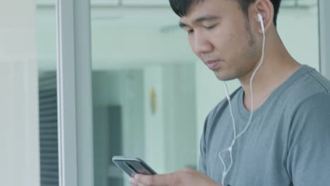 Joven-asiática-corriendo-en-la-caminadora-en-el-gimnasio-con-auriculares