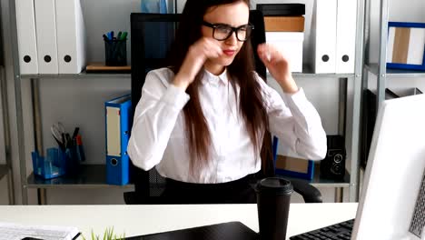 businesswoman-taking-off-glasses,holding-cup-and-smiling-in-modern-office.