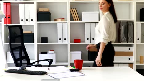 businesswoman-in-black-skirt-putting-folder-in-cabinet