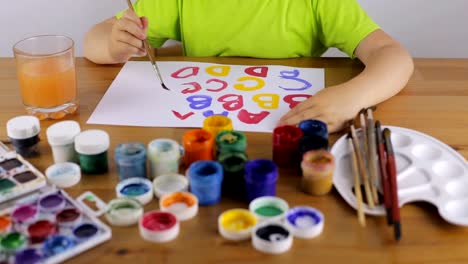 Child-learns-to-write-letters-with-paint