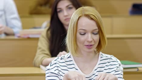 Smiling-Female-Student-Listening-to-Teacher