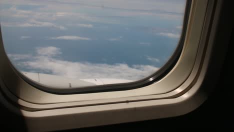 Airplane-engine-in-flight-view-through-an-airplane-window-seeing-clouds-for-travel-around-the-world