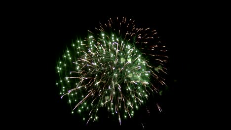 A-beautiful-fireball-is-in-the-middle-of-the-night-sky.-Yellow-saturated-color,-many-sparkling-lines-and-shine.-Two-fireworks-are-intertwined,-there-is-smoke-around