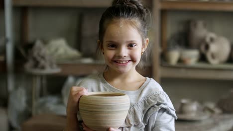 Niña-linda-posando-con-maceta-de-cerámica