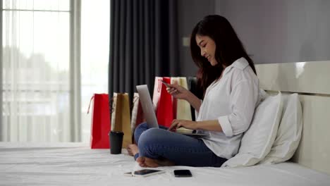 stressed-woman-using-laptop-for-online-shopping-on-a-bed,-and-having-problem-with-blocked-credit-card