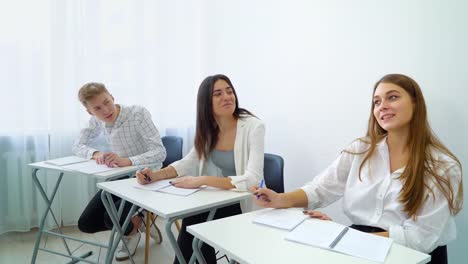 positive-lächelnde-Studentinnen-und-Studenten-üben-Teamarbeit-und-Kommunikationsfähigkeit-durchführen