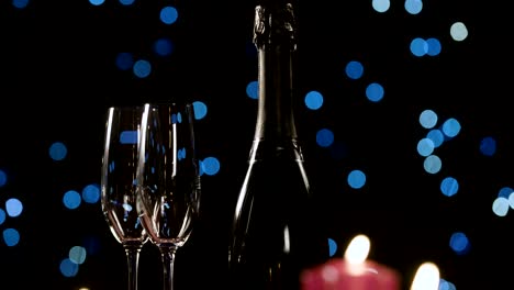 Two-glasses,-bottle-of-champagne-and-red-romantic-candles