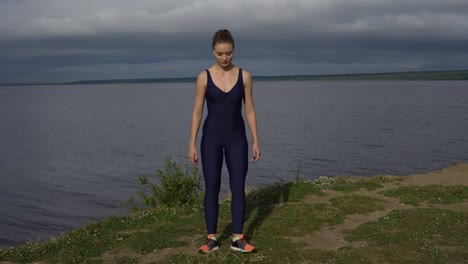 Mujer-de-yoga-en-ropa-deportiva-azul-se-extiende-al-aire-libre.