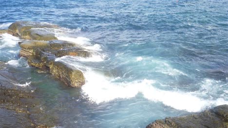 Formación-de-espuma-y-salpicaduras-de-olas-en-el-océano-con-el-estilo-de-cámara-lenta,-día-soleado-en-el-Parque-Chaojing,-ciudad-de-Keelung-de-Taiwán