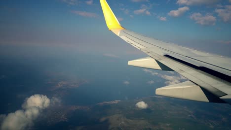 Vuelo-en-avión.-Ala-de-un-avión-volando-sobre-las-nubes-con-el-cielo-al-atardecer.-Vista-desde-la-ventana-del-avión.-Avión.-Viajando-por-el-aire.-4K-video-UHD