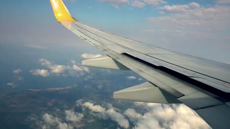 Vuelo-en-avión.-Ala-de-un-avión-volando-sobre-las-nubes-con-el-cielo-al-atardecer.-Vista-desde-la-ventana-del-avión.-Avión.-Viajando-por-el-aire.-4K-video-UHD