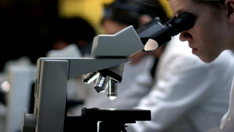 Students-in-a-lab-look-through-a-microscope-during-their-class