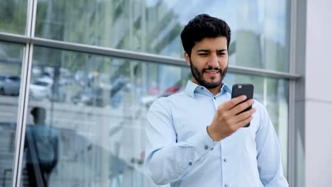 Handsome-Man-Using-Phone-Near-Business-Center-On-Street