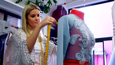 Fashion-designer-taking-measurement-of-dressmakers-model-4k