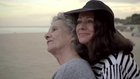 Beautiful-daughter-in-hat-laughing-and-hugging-elderly-mother