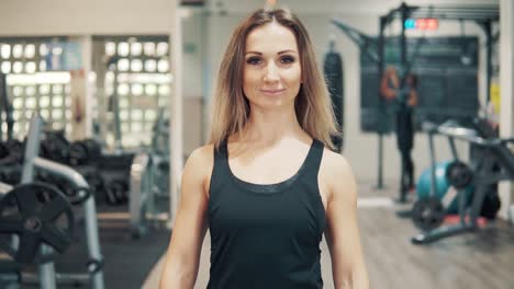 Slowmotion-shot-of-Young-fit-woman-walking-through-gym.