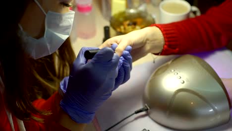 Woman-Covering-Nails-with-Gel-Polish-to-a-Client