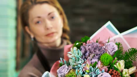 Frau-Blumengeschäft-mit-einen-schönen-Blumenstrauß.-Das-Bouquet-im-Vordergrund-mit-einem-unscharfen-Hintergrund.