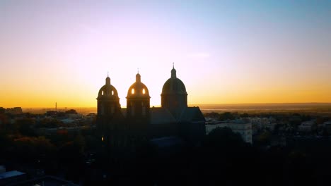 Vista-aérea-iglesia-al-atardecer-y-rayos-de-sol-4k