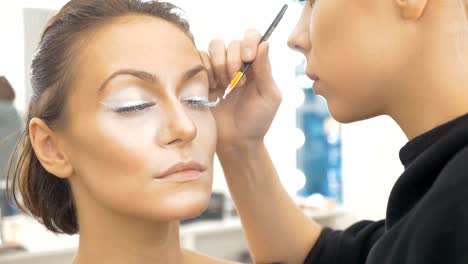 Professionelle-Visagistin,-malt-spezielle-weißen-Farbe,-Modell-Wimpern.