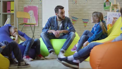 Kleine-Kinder-sprechen-mit-männlichen-Lehrer-im-Kindergarten-Lektion