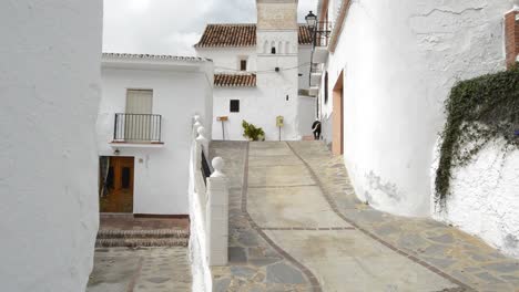 Street-in-the-andalusian-village-of-Daimalos-with-a-old-christian-church,-tilt