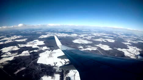 UHD-Flügel-eines-Flugzeugs-mit-blauem-Himmel-über-den-Wolken-fliegen