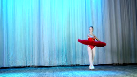 ballet-rehearsal,-on-the-stage-of-the-old-theater-hall.-Young-ballerina-in-red-ballet-tutu-and-pointe-shoes,-dances-elegantly-certain-ballet-motion,-tour-en-dedane