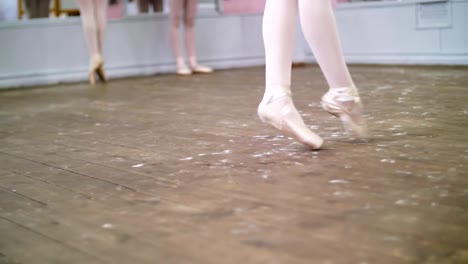 in-dancing-hall,-Young-ballerina-in-black-leotard-performs-glissade-en-tournant,-She-moving-through-the-ballet-class-elegantly